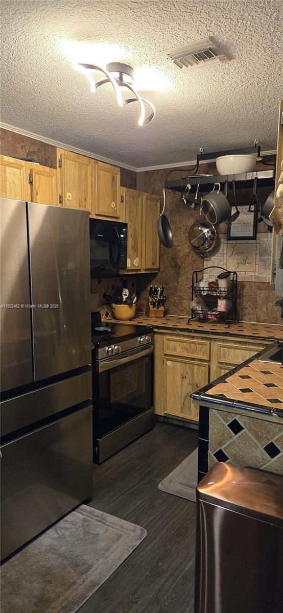 9750 NW 14th St Unit 30-5, Coral Springs, FL 33071 - kitchen with black microwave, freestanding refrigerator, electric range, dark wood finished floors, and a textured ceiling