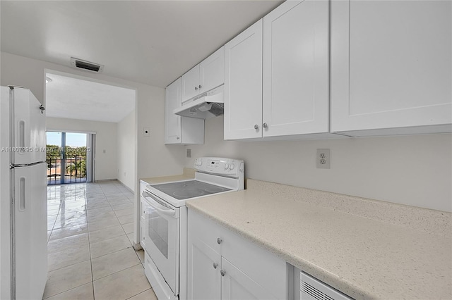 650 NE 149th St Unit 406A, Miami, FL 33161 - kitchen with white appliances, under cabinet range hood, white cabinetry, and light tile patterned floors