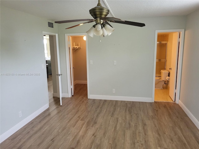 3150 W Rolling Hills Cir Unit 310, Davie, FL 33328 - unfurnished bedroom featuring a walk in closet, wood finished floors, a closet, ensuite bathroom, and ceiling fan