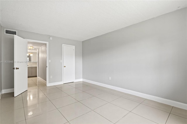 301 NW 177th St Unit 104, Miami Gardens, FL 33169 - unfurnished bedroom featuring a textured ceiling and light tile patterned floors