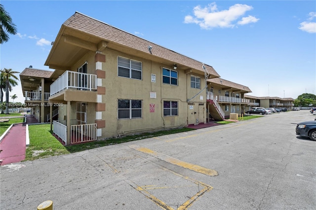 301 NW 177th St Unit 104, Miami Gardens, FL 33169 - view of building exterior with uncovered parking and stairs