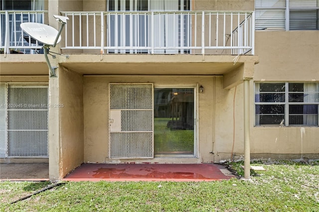301 NW 177th St Unit 104, Miami Gardens, FL 33169 - view of exterior entry featuring a balcony and stucco siding
