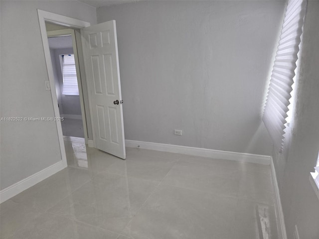 257 E 38th St, Hialeah, FL 33013 - spare room featuring baseboards and light tile patterned flooring