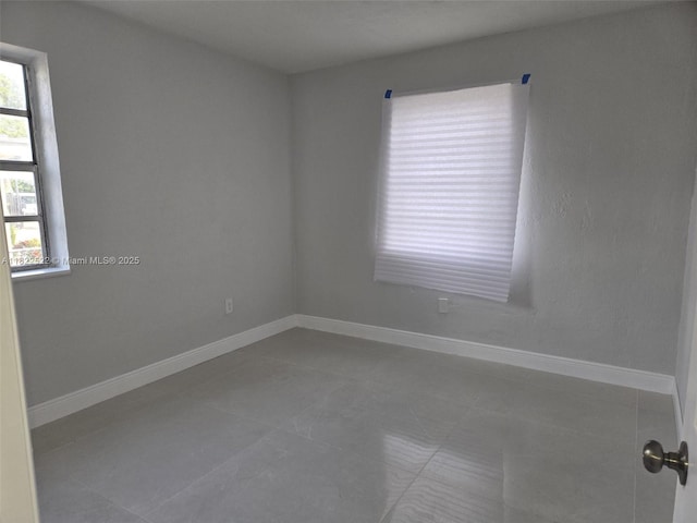 257 E 38th St, Hialeah, FL 33013 - tiled spare room featuring baseboards