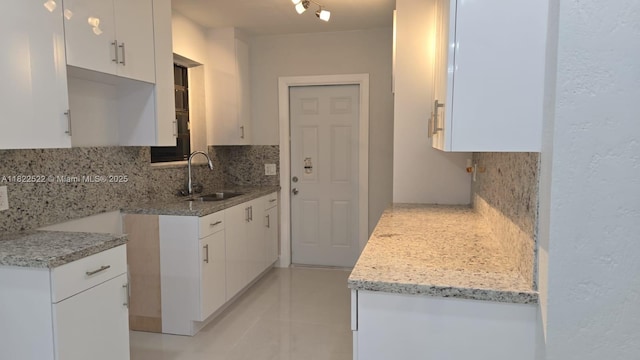257 E 38th St, Hialeah, FL 33013 - kitchen with backsplash, white cabinetry, light stone counters, and light tile patterned flooring