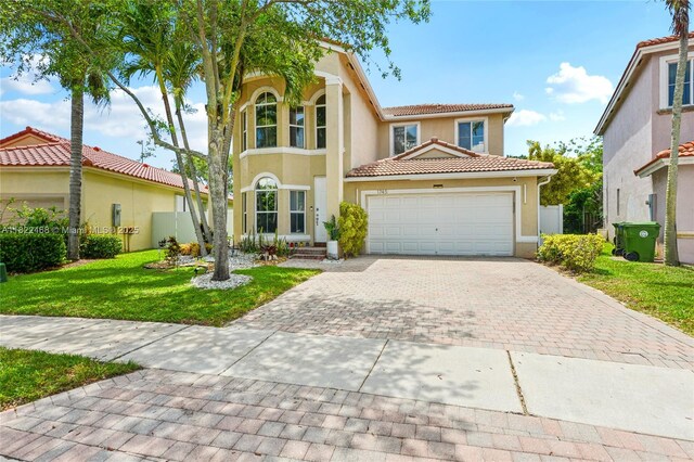 1745 NW 77th Ave, Pembroke Pines, FL 33024 - mediterranean / spanish home with driveway, a tile roof, stucco siding, a front lawn, and an attached garage