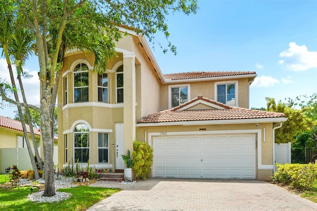 1745 NW 77th Ave, Pembroke Pines, FL 33024 - mediterranean / spanish-style house featuring decorative driveway, a tile roof, stucco siding, and an attached garage