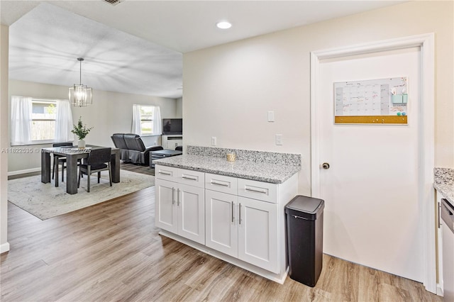 1712 Melvin Ave, Orlando, FL 32806 - kitchen featuring light wood-style flooring, a chandelier, light stone countertops, white cabinets, and recessed lighting