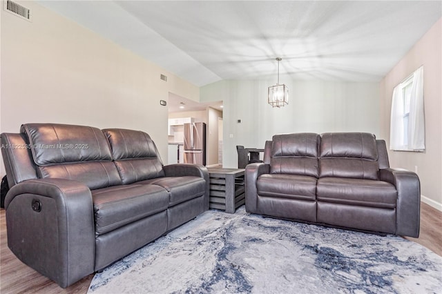 1712 Melvin Ave, Orlando, FL 32806 - living room with wood finished floors, a chandelier, and vaulted ceiling