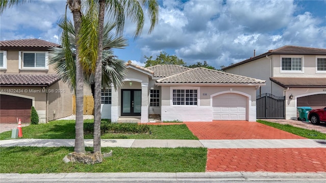 9408 SW 156th Pl, Miami, FL 33196 - view of front of home with decorative driveway, french doors, stucco siding, a garage, and a tile roof