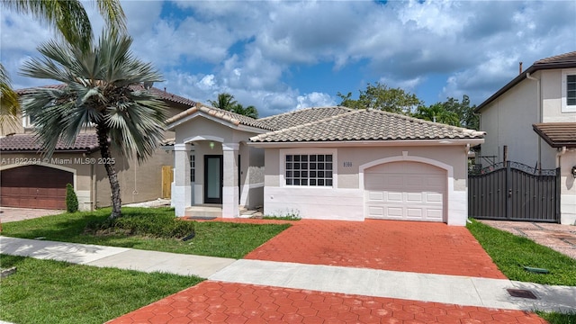 9408 SW 156th Pl, Miami, FL 33196 - mediterranean / spanish house featuring stucco siding, a garage, decorative driveway, a tile roof, and a gate