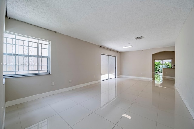 9408 SW 156th Pl, Miami, FL 33196 - spare room with a textured ceiling, arched walkways, and light tile patterned floors