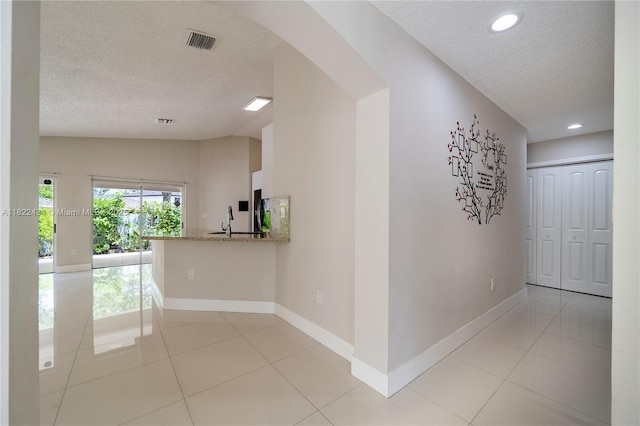 9408 SW 156th Pl, Miami, FL 33196 - hall featuring a textured ceiling, light tile patterned floors, arched walkways, and recessed lighting