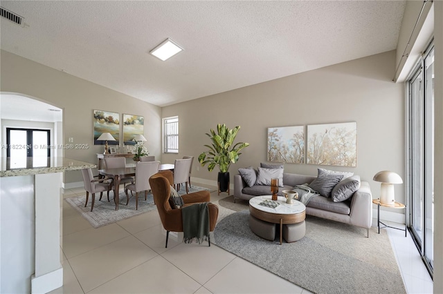 9408 SW 156th Pl, Miami, FL 33196 - living area featuring arched walkways, vaulted ceiling, a textured ceiling, and light tile patterned flooring