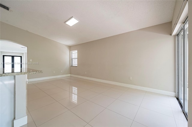 9408 SW 156th Pl, Miami, FL 33196 - unfurnished room featuring arched walkways, a textured ceiling, and light tile patterned floors