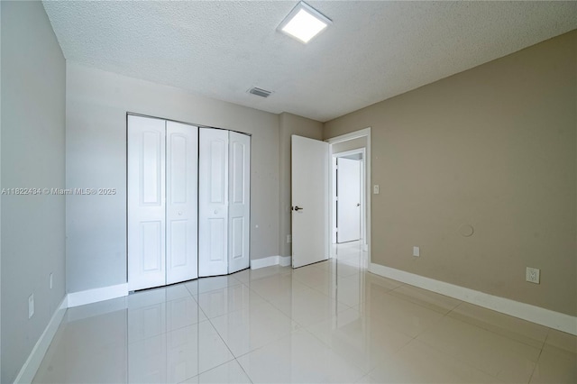 9408 SW 156th Pl, Miami, FL 33196 - unfurnished bedroom with a textured ceiling, a closet, and light tile patterned floors