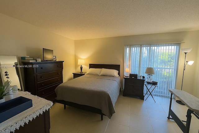 801 SW 133rd Ter Unit 308K, Pembroke Pines, FL 33027 - bedroom featuring access to exterior, light tile patterned floors, and a textured ceiling