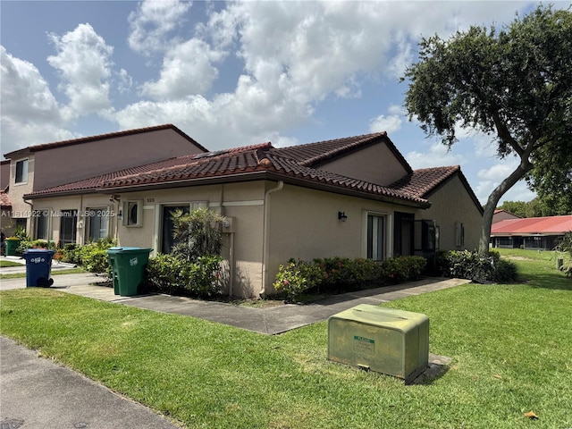 3313 W Inverrary Blvd W, Lauderhill, FL 33319 - view of side of property with a yard, stucco siding, and a tiled roof