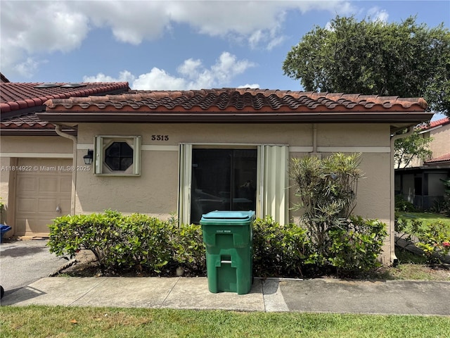 3313 W Inverrary Blvd W, Lauderhill, FL 33319 - view of exterior entry with stucco siding, a tile roof, and an attached garage