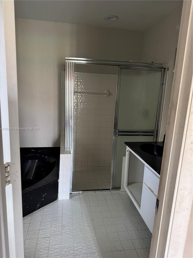 3313 W Inverrary Blvd W, Lauderhill, FL 33319 - bathroom featuring tile patterned floors, a garden tub, a shower stall, and vanity