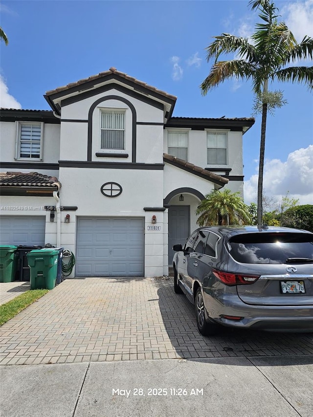 11401 NW 76th Ter, Doral, FL 33178 - townhome / multi-family property with an attached garage, stucco siding, and decorative driveway