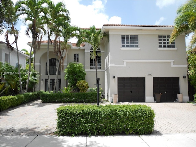 12940 SW 142nd Ter, Miami, FL 33186 - mediterranean / spanish-style home with stucco siding, an attached garage, a tile roof, and driveway