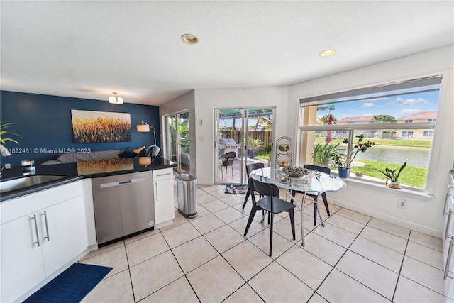 11018 NW 47th Ter, Doral, FL 33178 - kitchen featuring stainless steel dishwasher, dark countertops, white cabinetry, a water view, and light tile patterned flooring