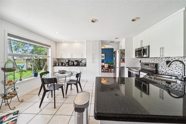 11018 NW 47th Ter, Doral, FL 33178 - kitchen with appliances with stainless steel finishes, light tile patterned floors, tasteful backsplash, a peninsula, and white cabinetry