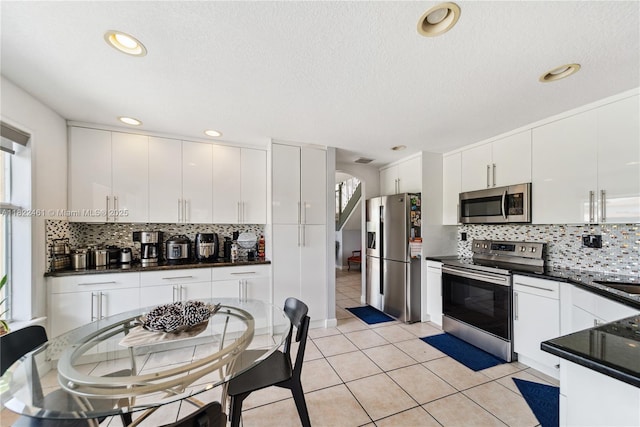 11018 NW 47th Ter, Doral, FL 33178 - kitchen featuring stainless steel appliances, dark countertops, tasteful backsplash, white cabinets, and recessed lighting