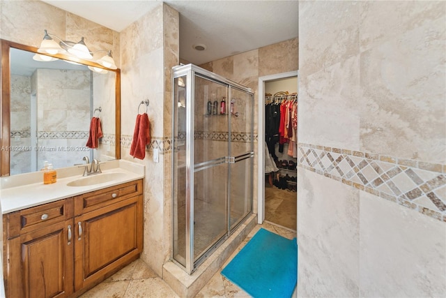 11018 NW 47th Ter, Doral, FL 33178 - full bathroom with a shower stall, vanity, tile walls, and a walk in closet