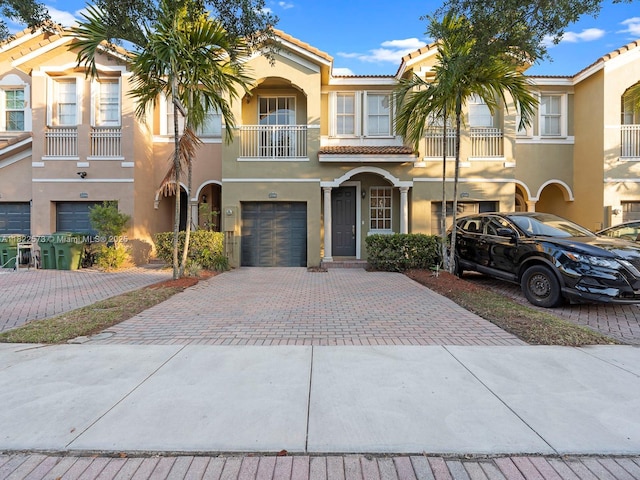 2590 SE 14th St, Homestead, FL 33035 - view of front of property with decorative driveway, stucco siding, an attached garage, a tile roof, and a balcony