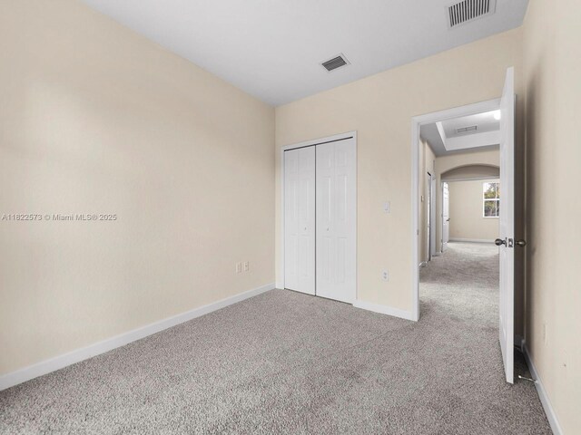 2590 SE 14th St, Homestead, FL 33035 - unfurnished bedroom featuring carpet, arched walkways, and a closet