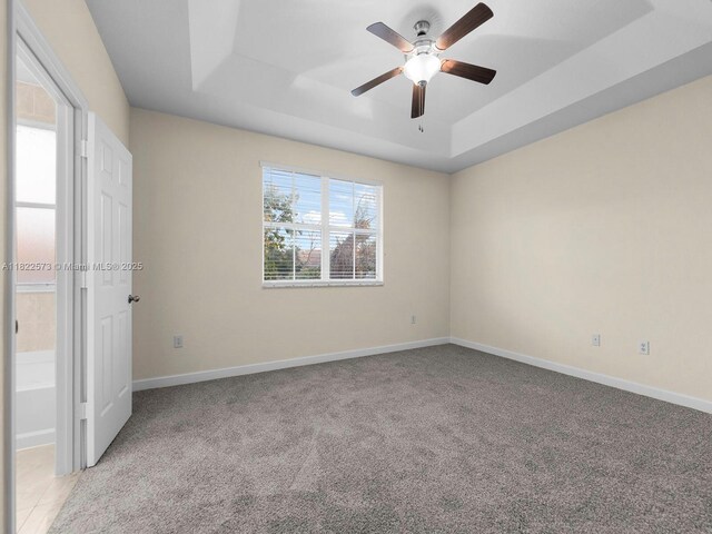 2590 SE 14th St, Homestead, FL 33035 - unfurnished bedroom with a tray ceiling, carpet floors, and ceiling fan