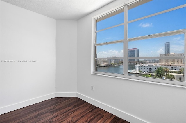 1965 S Ocean Dr Unit 6Q, Hallandale Beach, FL 33009 - spare room featuring dark wood-type flooring, a view of city, a water view, and a textured ceiling