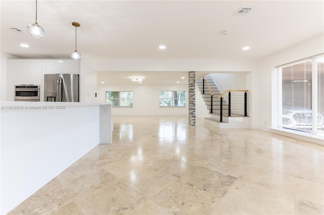 unfurnished living room featuring stairway and recessed lighting