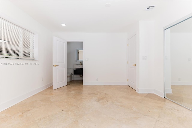 spare room featuring recessed lighting and baseboards