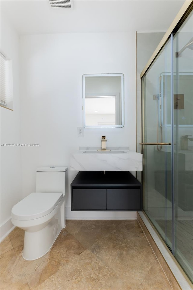 full bath featuring a shower stall, vanity, and stone finish floors