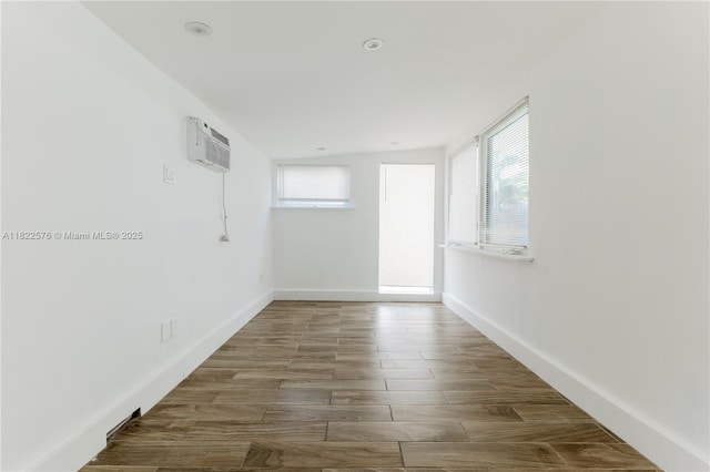 empty room featuring an AC wall unit and wood finished floors
