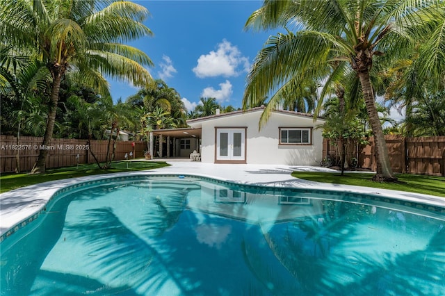 view of pool featuring french doors, a patio, and a fenced backyard