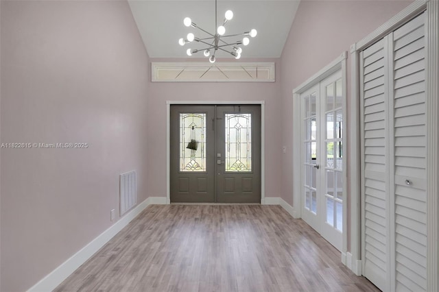7220 NW 44th Ct, Lauderhill, FL 33319 - foyer entrance with french doors, a chandelier, wood finished floors, and lofted ceiling