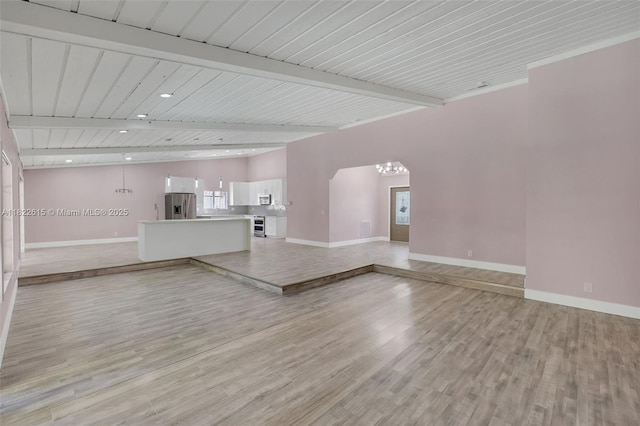 7220 NW 44th Ct, Lauderhill, FL 33319 - unfurnished living room featuring light wood finished floors, a chandelier, arched walkways, beamed ceiling, and recessed lighting
