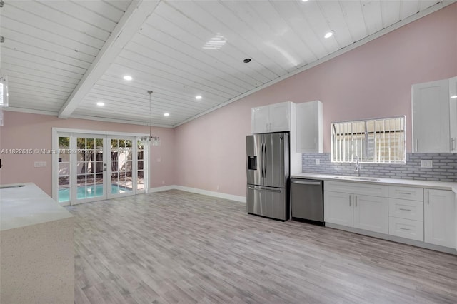 7220 NW 44th Ct, Lauderhill, FL 33319 - kitchen with stainless steel appliances, french doors, decorative backsplash, healthy amount of natural light, and lofted ceiling