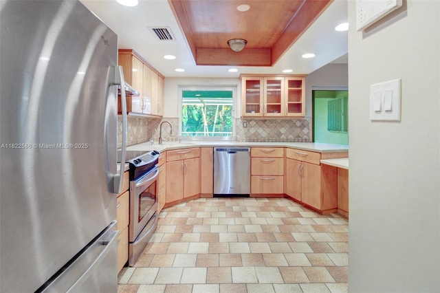 1531 SW 67th Ter, Plantation, FL 33317 - kitchen featuring appliances with stainless steel finishes, a tray ceiling, tasteful backsplash, glass insert cabinets, and recessed lighting