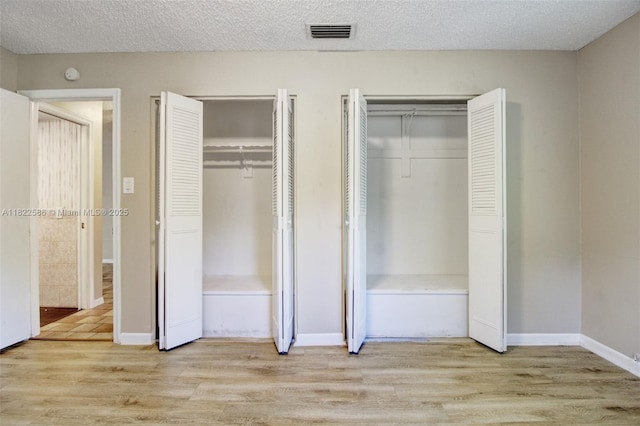 1531 SW 67th Ter, Plantation, FL 33317 - unfurnished bedroom with two closets, light wood-style flooring, and a textured ceiling