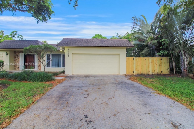 1531 SW 67th Ter, Plantation, FL 33317 - view of front of home with driveway, stucco siding, a garage, and roof with shingles