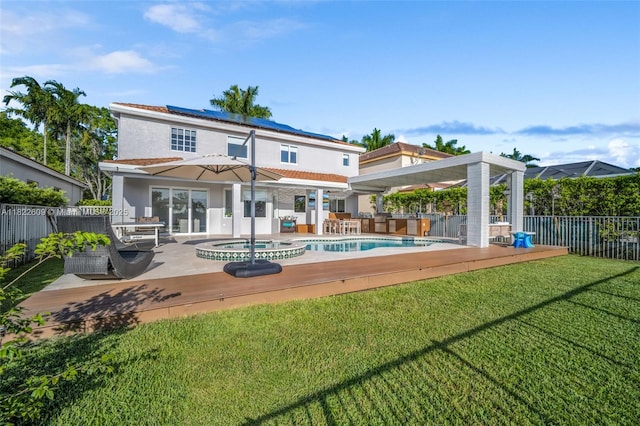 942 Lavender Cir, Weston, FL 33327 - back of house with solar panels, a fenced backyard, a patio area, stucco siding, and a pool with connected hot tub