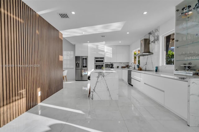 942 Lavender Cir, Weston, FL 33327 - kitchen with modern cabinets, appliances with stainless steel finishes, island exhaust hood, white cabinetry, and a kitchen island