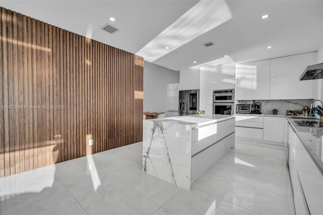 942 Lavender Cir, Weston, FL 33327 - kitchen with modern cabinets, stainless steel appliances, white cabinetry, a center island, and backsplash