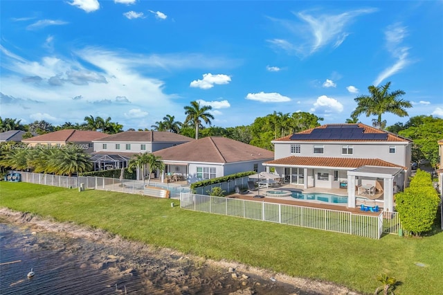 942 Lavender Cir, Weston, FL 33327 - rear view of house with roof mounted solar panels, a fenced backyard, a tile roof, a patio area, and a pool with connected hot tub