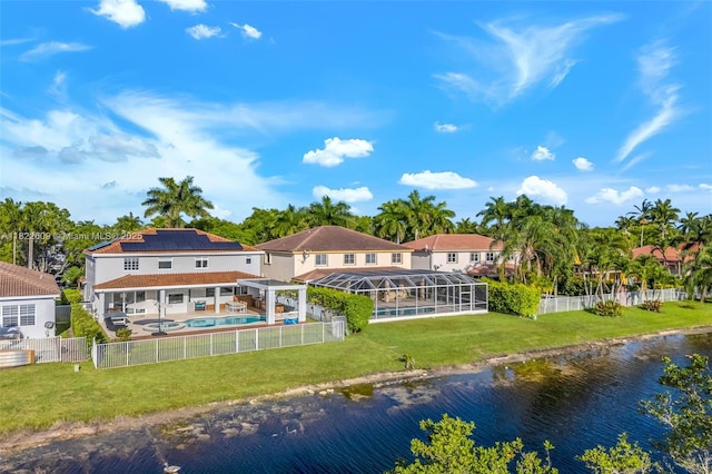 942 Lavender Cir, Weston, FL 33327 - rear view of property with an outdoor pool, a water view, a fenced backyard, solar panels, and a patio area